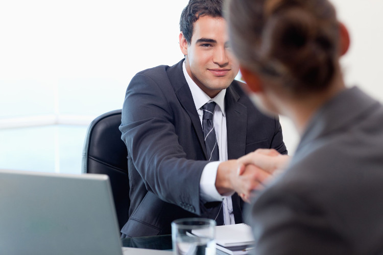 Candidate shakes hands with employer during interview